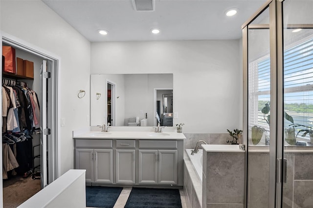 1123 Dora Parc Ln, Mount Dora, FL 32757 - bathroom with double vanity, a bath, a walk in closet, and recessed lighting