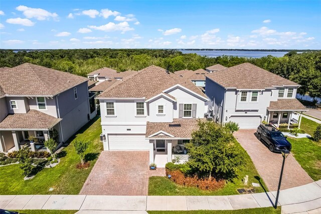 1123 Dora Parc Ln, Mount Dora, FL 32757 - view of front of property with decorative driveway, a garage, stucco siding, and a water view