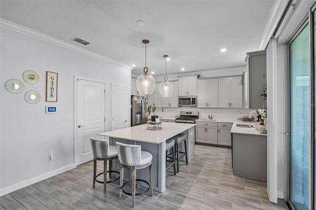 1123 Dora Parc Ln, Mount Dora, FL 32757 - kitchen featuring stainless steel appliances, a sink, a breakfast bar, gray cabinetry, and light countertops