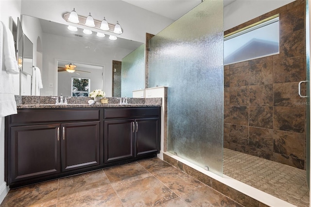 8692 Tavistock Lakes Blvd, Orlando, FL 32827 - bathroom featuring tiled shower, double vanity, and ceiling fan