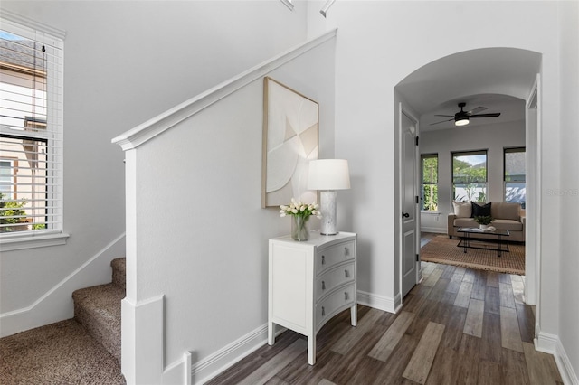 8692 Tavistock Lakes Blvd, Orlando, FL 32827 - hall featuring arched walkways, dark wood-style flooring, and stairs