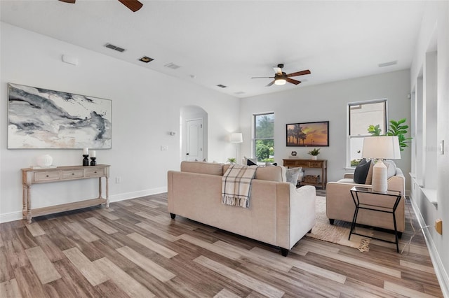 8692 Tavistock Lakes Blvd, Orlando, FL 32827 - living room featuring a ceiling fan, arched walkways, and wood finished floors