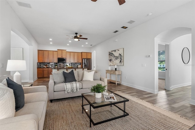 8692 Tavistock Lakes Blvd, Orlando, FL 32827 - living room featuring a ceiling fan, arched walkways, light wood finished floors, and recessed lighting