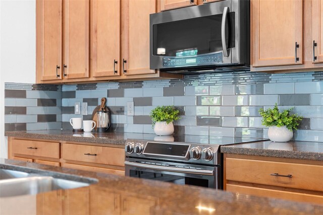 8692 Tavistock Lakes Blvd, Orlando, FL 32827 - kitchen featuring appliances with stainless steel finishes, backsplash, and dark countertops