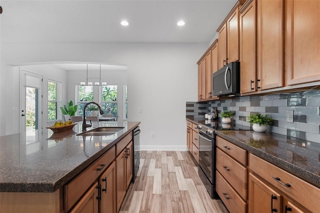 8692 Tavistock Lakes Blvd, Orlando, FL 32827 - kitchen featuring black appliances, light wood-style flooring, backsplash, recessed lighting, and brown cabinetry