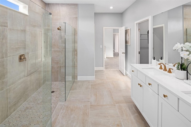 bathroom featuring tiled shower, vanity, recessed lighting, baseboards, and a spacious closet