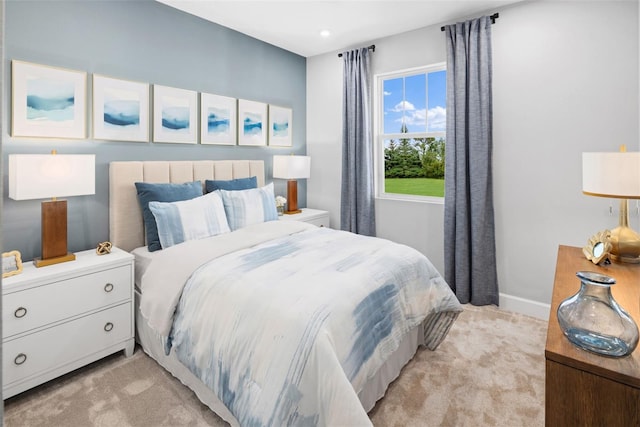 bedroom featuring light carpet and baseboards