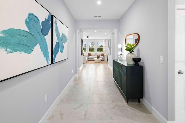 hall with baseboards, light marble finish floors, and recessed lighting
