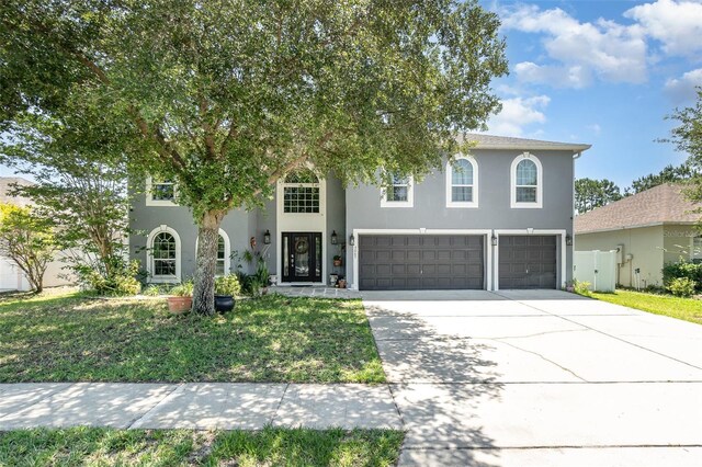 3063 Mandolin Dr, Kissimmee, FL 34744 - view of front of property with a garage, stucco siding, and concrete driveway