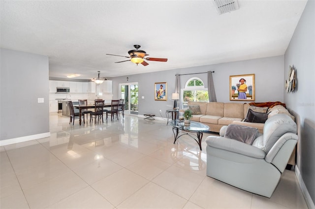3063 Mandolin Dr, Kissimmee, FL 34744 - living room with a ceiling fan, light tile patterned floors, and baseboards