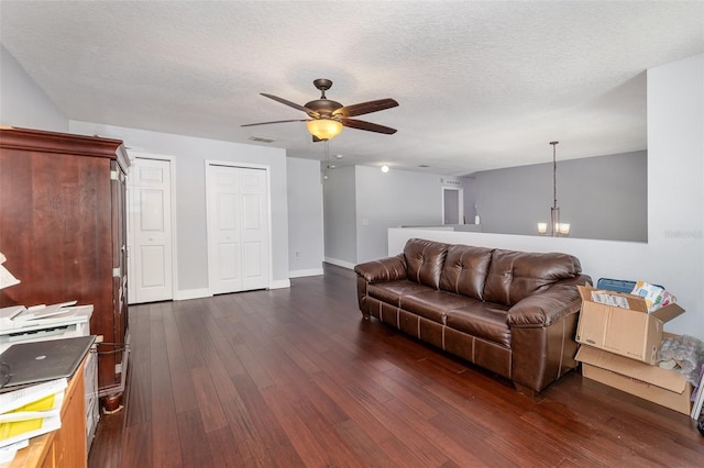 3063 Mandolin Dr, Kissimmee, FL 34744 - living area featuring a ceiling fan, dark wood-style floors, a chandelier, baseboards, and a textured ceiling