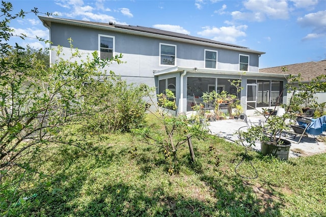 3063 Mandolin Dr, Kissimmee, FL 34744 - back of property featuring a patio, a sunroom, and stucco siding