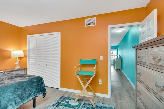 bedroom featuring wood finished floors, a closet, and baseboards