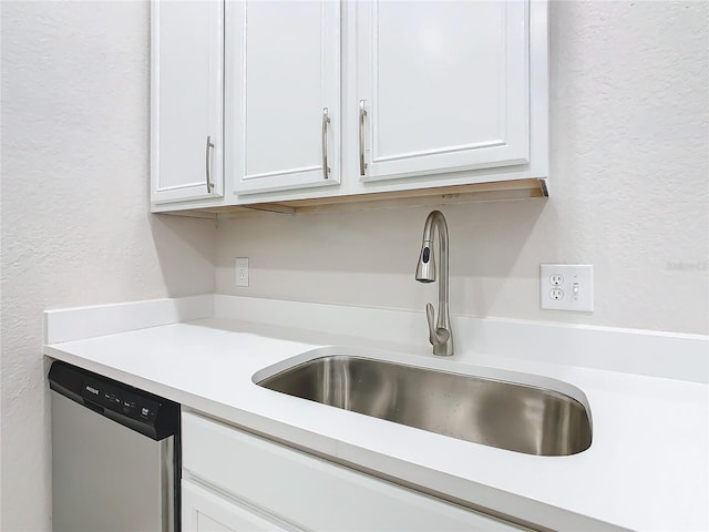 3000 Laurel Park Ln Unit 202, Kissimmee, FL 34741 - kitchen view of dishwasher, a sink, light countertops, white cabinets, and a textured wall