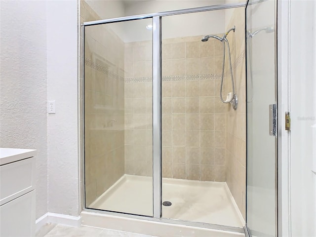 3000 Laurel Park Ln Unit 202, Kissimmee, FL 34741 - full bath with a textured wall, a shower stall, vanity, and baseboards