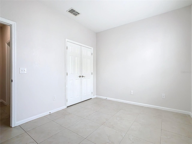 3000 Laurel Park Ln Unit 202, Kissimmee, FL 34741 - unfurnished bedroom featuring light tile patterned flooring, a closet, and baseboards