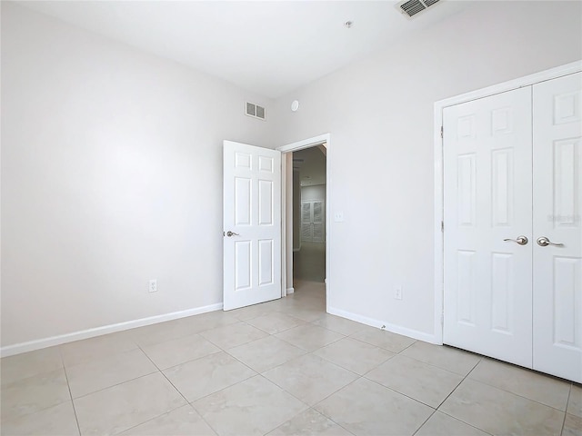 3000 Laurel Park Ln Unit 202, Kissimmee, FL 34741 - unfurnished bedroom featuring baseboards, light tile patterned floors, and a closet
