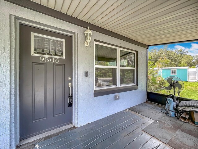 9506 Number Two Rd, Howey In The Hills, FL 34737 - doorway to property with covered porch and stucco siding
