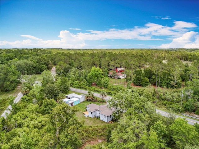 aerial view of property and surrounding area with a heavily wooded area