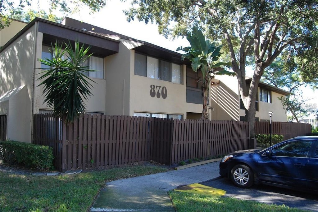 870 Village Lake Ter N Unit 204, Saint Petersburg, FL 33716 - view of side of property featuring stucco siding and fence