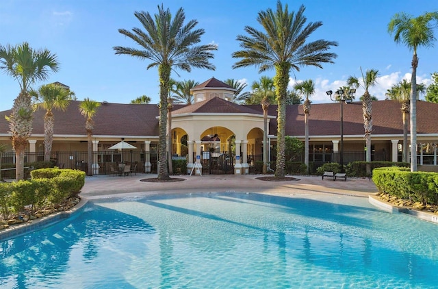 community pool with fence and a patio area