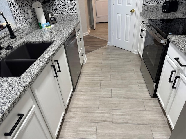 kitchen with electric stove, wood tiled floors, a sink, stainless steel dishwasher, and backsplash