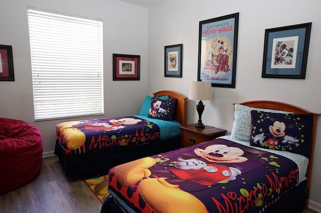 bedroom with wood finished floors, multiple windows, and baseboards