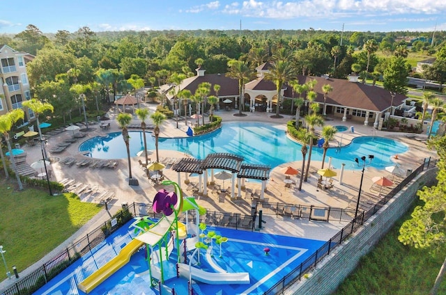 community pool featuring a water play area, a gazebo, fence, and a patio area