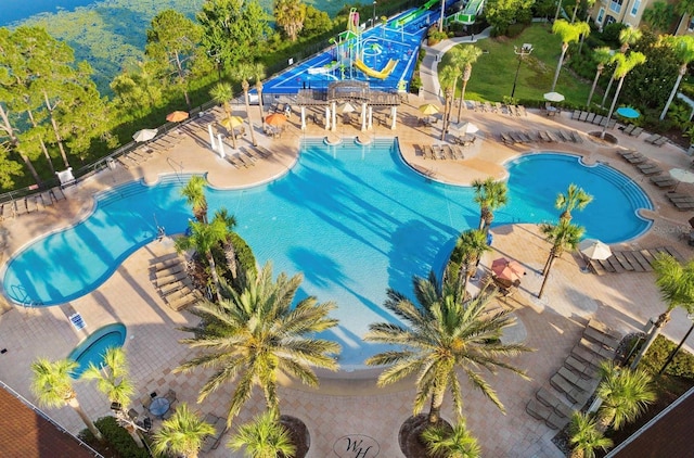community pool featuring a water slide and a patio