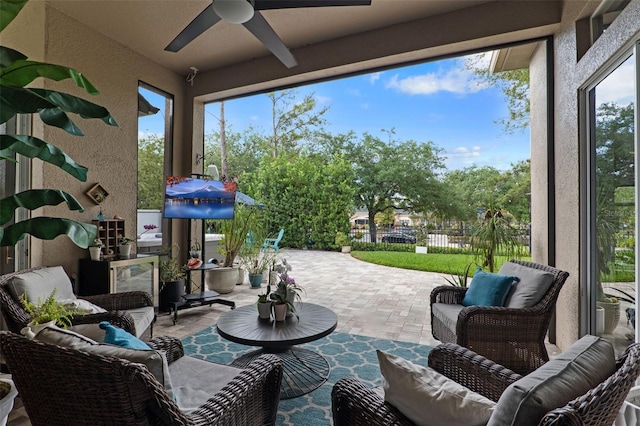 view of patio with an outdoor living space, ceiling fan, and fence