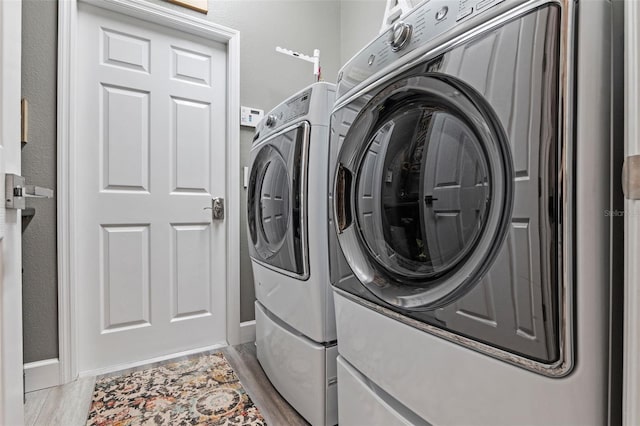 laundry room featuring independent washer and dryer and wood finished floors