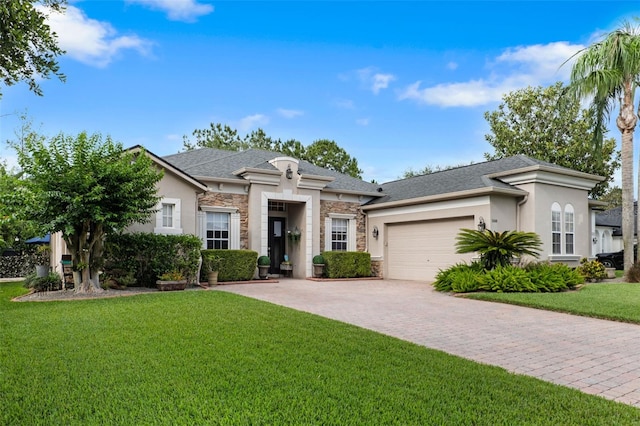 view of front facade with stucco siding, stone siding, an attached garage, a front lawn, and driveway