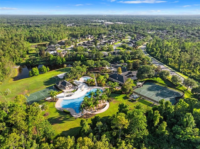 drone / aerial view of a forest and a pool area