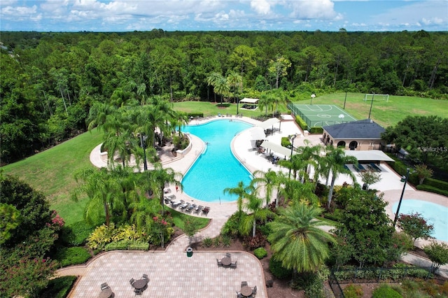 drone / aerial view of a forest and a pool area