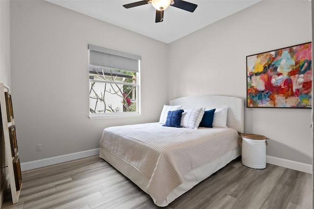 bedroom with wood finished floors, baseboards, and ceiling fan
