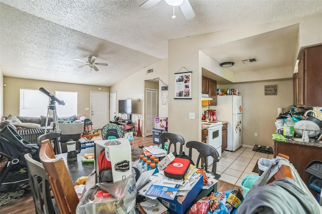 3711 Shady Grove Cir, Orlando, FL 32810 - dining area with ceiling fan, a textured ceiling, light tile patterned floors, and vaulted ceiling