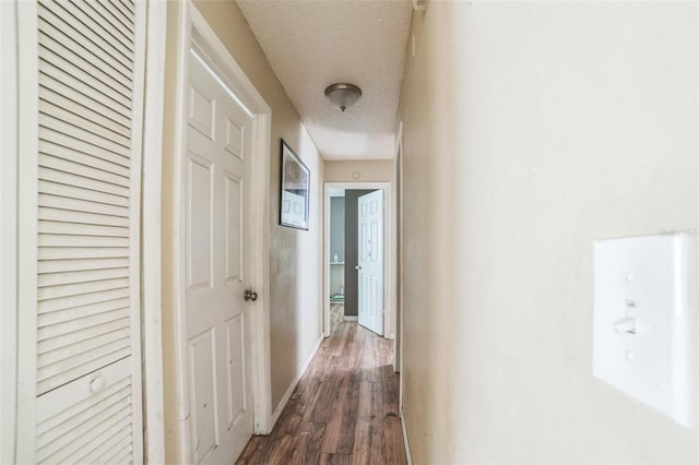 3711 Shady Grove Cir, Orlando, FL 32810 - hall with dark wood-style flooring, a textured ceiling, and baseboards