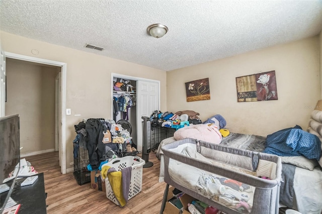 3711 Shady Grove Cir, Orlando, FL 32810 - bedroom featuring a closet, wood finished floors, a textured ceiling, and baseboards