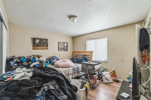 3711 Shady Grove Cir, Orlando, FL 32810 - bedroom with wood finished floors, a textured ceiling, and a closet
