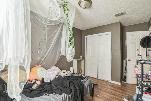 3711 Shady Grove Cir, Orlando, FL 32810 - bedroom with a closet, wood finished floors, baseboards, and a textured ceiling