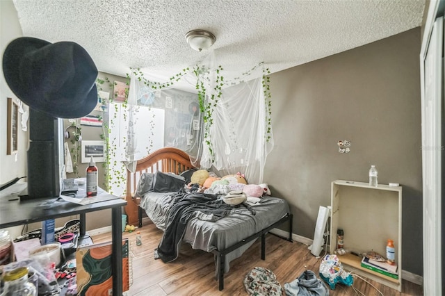3711 Shady Grove Cir, Orlando, FL 32810 - bedroom with a textured ceiling and wood finished floors