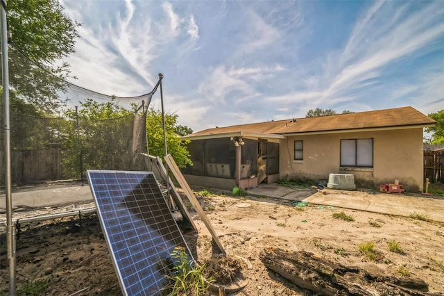 3711 Shady Grove Cir, Orlando, FL 32810 - back of property with a sunroom, stucco siding, and fence