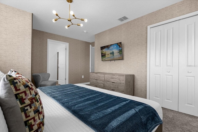 carpeted bedroom with a chandelier and a closet