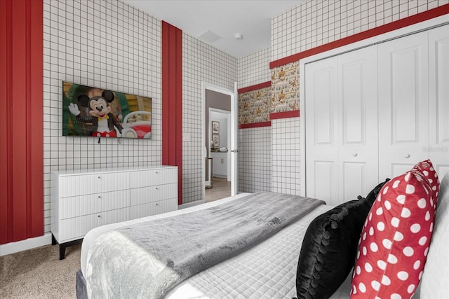 carpeted bedroom featuring a closet and baseboards