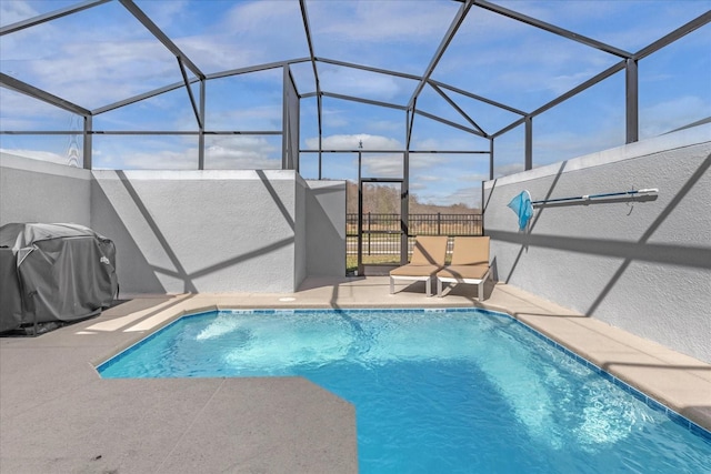 view of pool featuring a patio area, grilling area, and glass enclosure