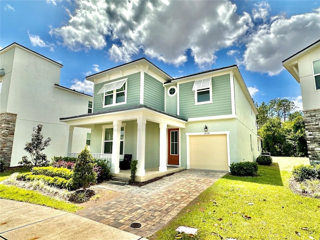 view of front of home featuring covered porch, decorative driveway, a garage, a front lawn, and stucco siding