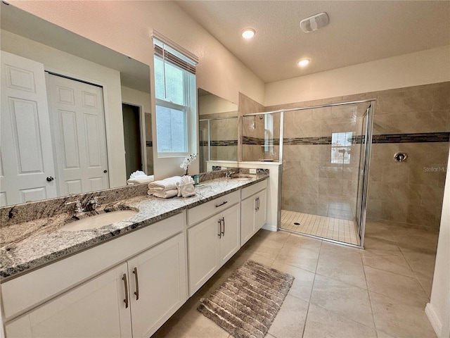 full bath featuring a stall shower, double vanity, tile patterned floors, and recessed lighting
