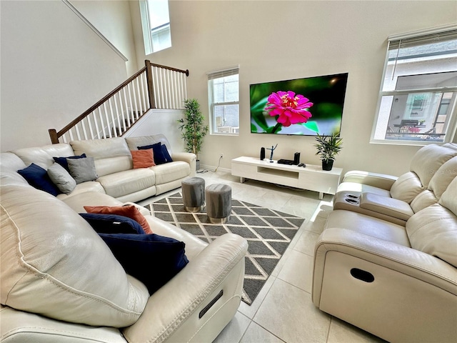 tiled living room featuring a high ceiling and stairs