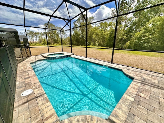 view of pool with a pool with connected hot tub, a patio area, and glass enclosure