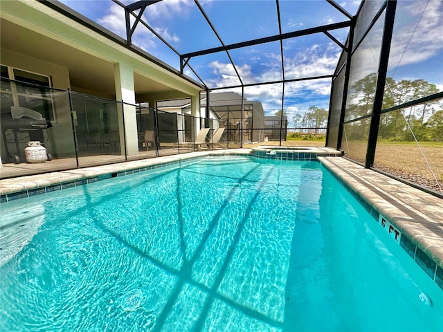 view of swimming pool with a pool with connected hot tub, a patio area, and glass enclosure